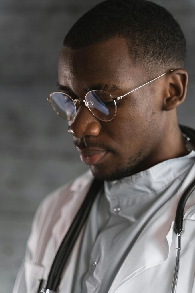 Close-up of a medical professional wearing eyeglasses and a stethoscope, portraying focus and diligence.